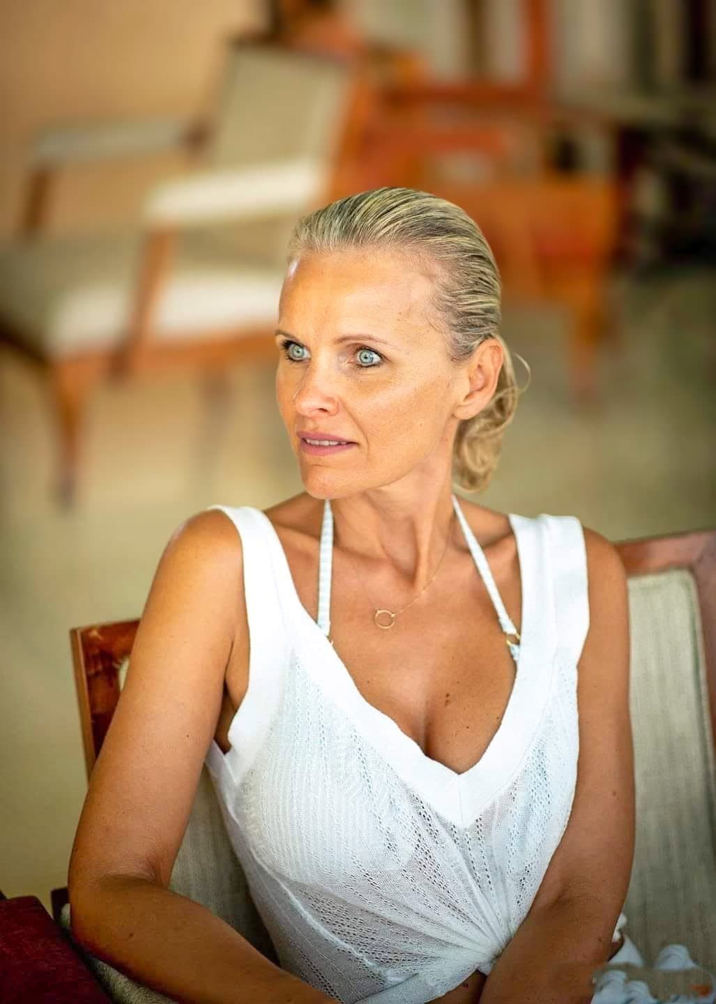 Femme en haut blanc assise en intérieur, portrait en lumière naturelle